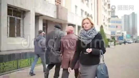 穿着暖和的衣服和围巾的女人走在街上。视频