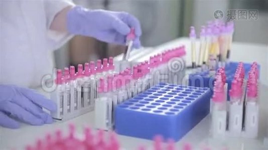 科学家，医生在现代明亮的实验室用血样检查试管。视频