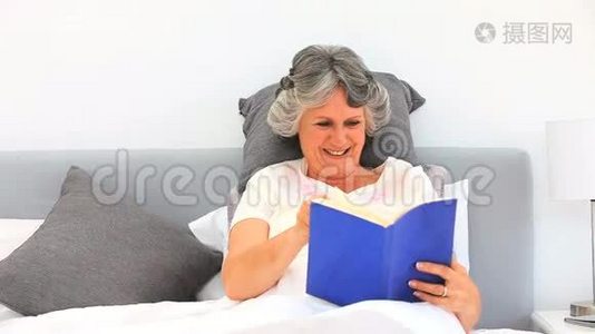 一个年轻的女人在床上看书视频