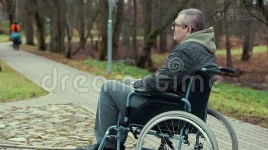 坐轮椅的残疾人在公园的小路上等候视频
