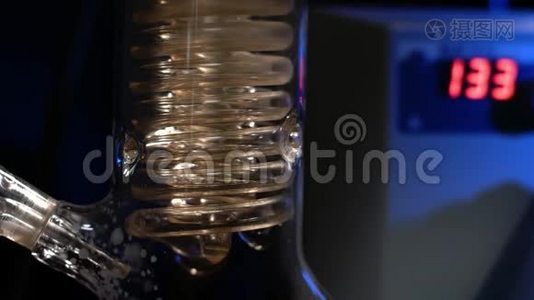 水晶螺旋。 螺旋玻璃管与水关闭。 玻璃螺旋管从回流冷凝器与自来水视频