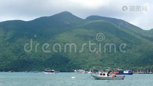 小船躺在宁静的海湾前的大山景视频