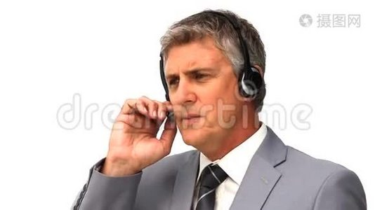 穿灰色西装的商人在耳机上讲话视频