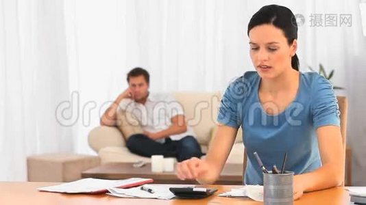 丈夫在沙发上的时候，女人在计算账单视频