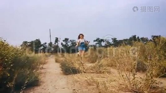 快乐的女孩朝风力涡轮机跑去，慢动作。视频