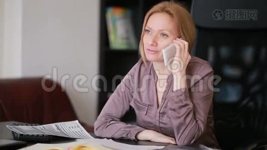 有魅力的女商人在办公室里拿着电脑和文件，打着电话视频