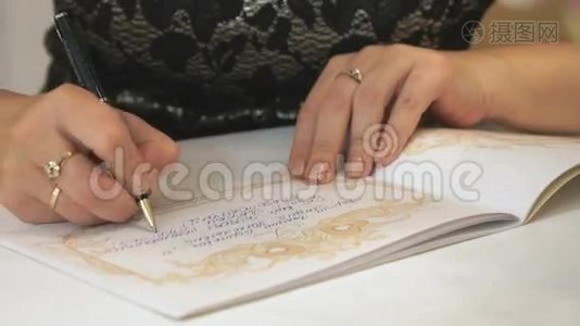 女性手写问候文字在书中。 关门视频