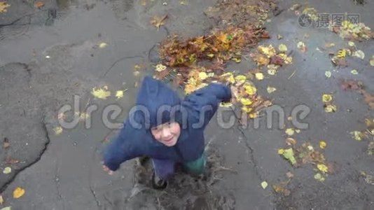 小男孩在泥泞的水坑里跳，慢动作250英尺视频