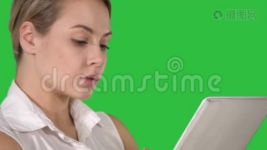 年轻有魅力的商业女性，手里拿着一台平板电脑在绿色屏幕上，Chroma键。视频