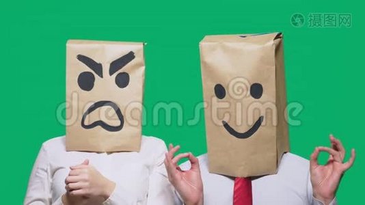 情绪和手势的概念.. 两个人头上装着纸袋，上面画着微笑。 咄咄逼人的微笑视频