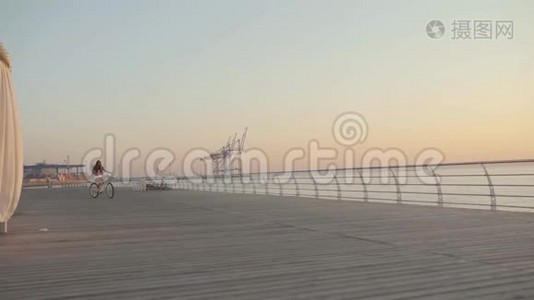 日出或日落时，年轻迷人的女士骑着老式自行车在海边视频