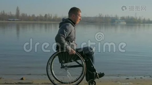 轮椅上的瘸子在河边，残疾人对未来的信心，男人与视频