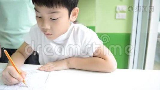 亚洲妈妈正在帮她儿子做学校的家庭作业视频