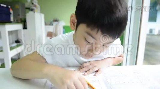 亚洲孩子用铅笔，做学校的作业视频