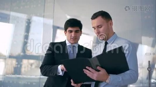 两个英俊的商人讨论文件视频