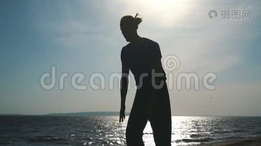 在日落海滩做瑜伽的年轻人剪影视频