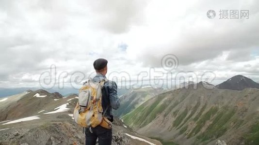 徒步旅行者背着背包站在山顶，举起双手欣赏日出视频