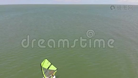 一个人用帆浮在冲浪板上。 空中射击视频