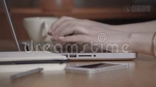 特写一只女手忙着在笔记本电脑上打字。视频