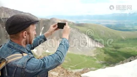 强壮的徒步旅行者在山顶用智能手机拍照。 奇妙的黎明。视频