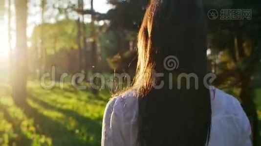 日落时分在森林里散步的女人。 慢动作视频