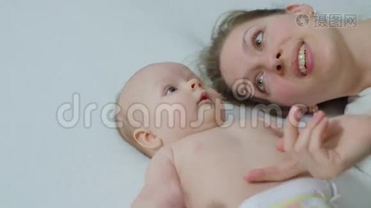 母亲和婴儿在床上拥抱。视频