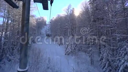 滑雪缆车上的雪林和滑雪者视频