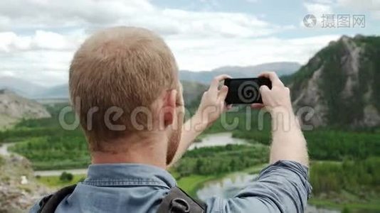 强壮的徒步旅行者在山顶用智能手机拍照。 奇妙的黎明。视频