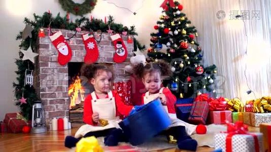 两个戴着圣诞老人帽子的小女孩坐在地上视频
