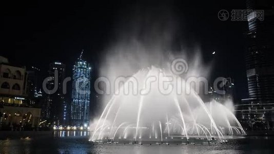 夜晚在城市里用灯光跳舞的喷泉。视频