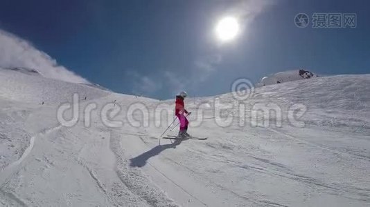 阳光明媚的冬山滑雪坡上滑雪的女滑雪者视频