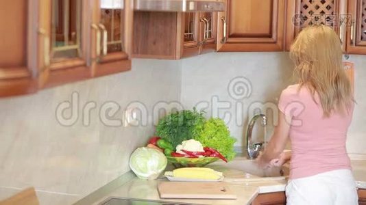 女孩洗葡萄。 厨房桌子上的蔬菜。 西红柿和卷心菜视频