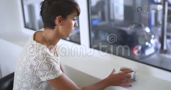 一位年轻漂亮的女士在轮胎试衣间喝咖啡视频