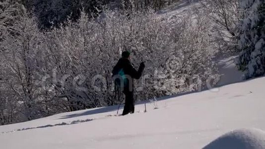 一个孤独的游客走过山林中的雪。 冬天雪林里的旅行者。 一个年轻人视频