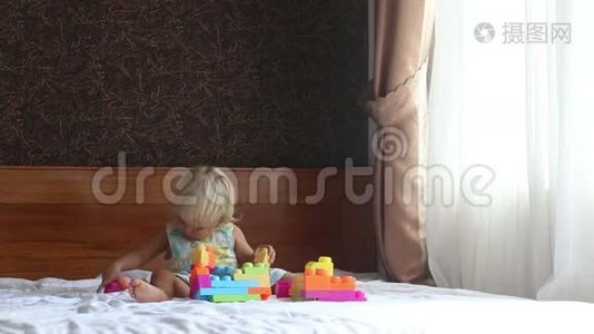 小金发女孩在沙发上玩玩具构造器视频
