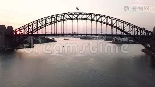 日出期间悉尼海港大桥的空中电影无人机镜头。视频