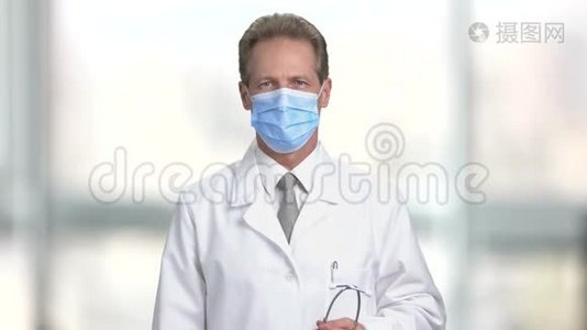 戴防护面罩的肖像医生使用听诊器..视频