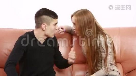 漂亮的年轻夫妇坐在沙发上争论不开心。 青年男女视频