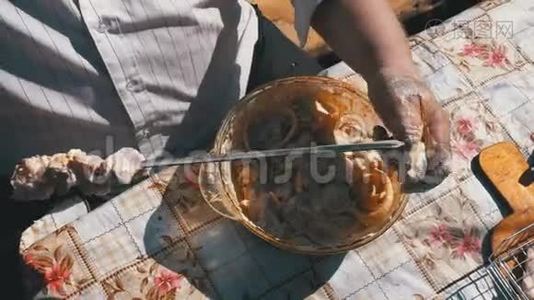 胖子把腌制的生肉放在一个绞架上，以求在大自然上做一个ShishKebab。视频