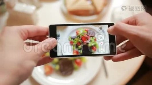 餐馆里的时髦男人用手机相机拍食物。视频