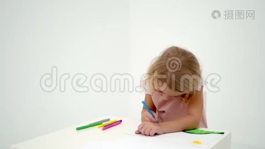 一个小女孩在桌子旁画画。视频