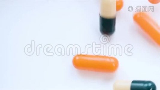 大量的药丸落在白色背景的顶部，以缓慢的运动。视频