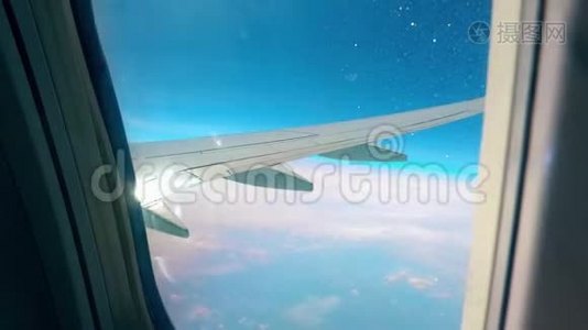 在天空中飞行时，飞机机翼在窗口中。视频