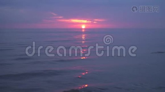 令人惊叹的黑暗风景，生动的深红色日落，在波罗的海有紫色和洋红色，在小太阳下。视频
