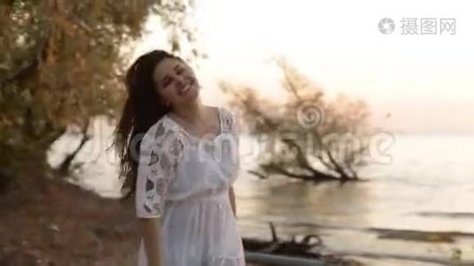 美丽快乐微笑的女人在海上日落慢动作视频