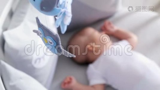 新生儿躺在白色的圆床上，有移动设备视频