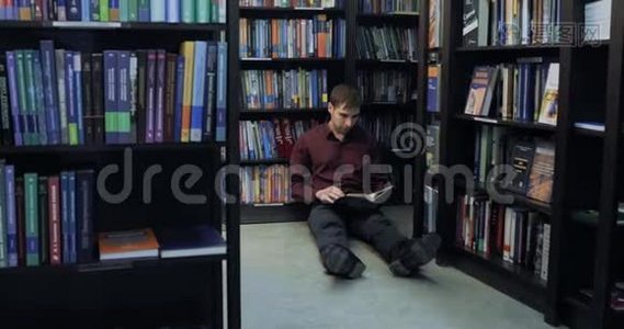 白种人坐在图书馆的地板上看书。视频