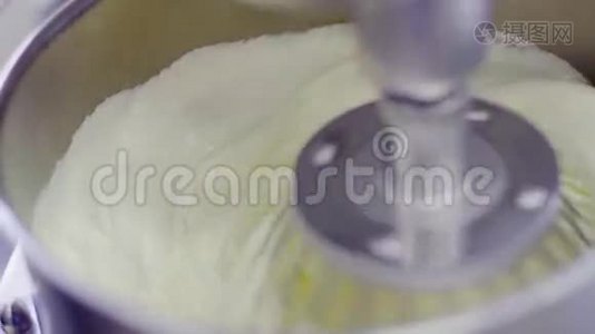 电动搅拌器将奶油倒入金属碗中视频