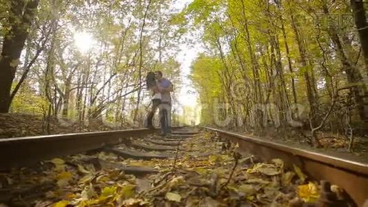 一对年轻夫妇在秋天公园接吻。视频