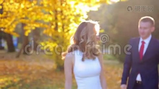 阳光明媚的秋天公园里美丽的年轻夫妇视频